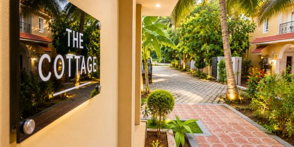 Entrance of The Cottage with tropical landscaping and warm lighting.