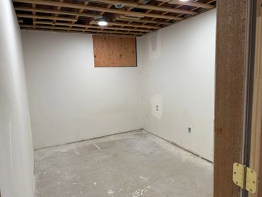 Empty unfinished room with exposed ceiling and concrete floor.