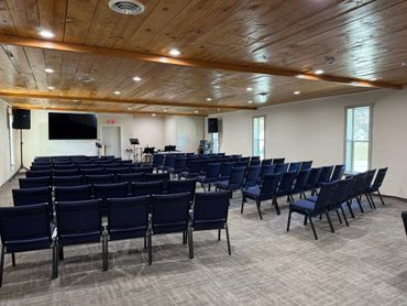 Empty conference room with rows of chairs and a wooden ceiling.