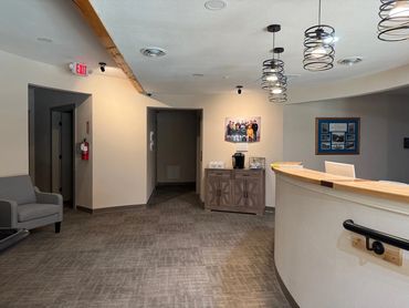 Interior of a cozy office reception area with a coffee bar and seating.