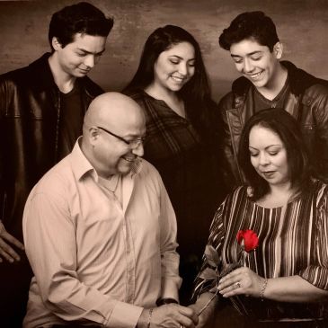 Family sharing a warm moment with a red rose.