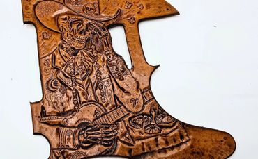 Intricately carved leather artwork depicting a skeletal figure playing guitar.