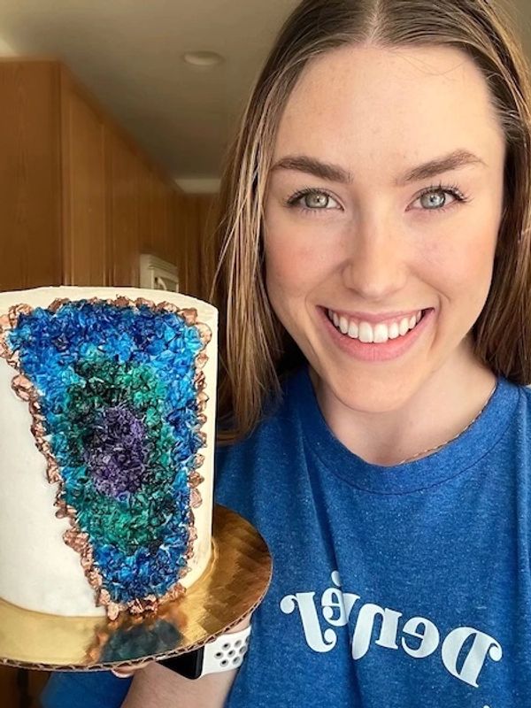 Owner Aleksandra Kay from Kaykery holding a geode cake.