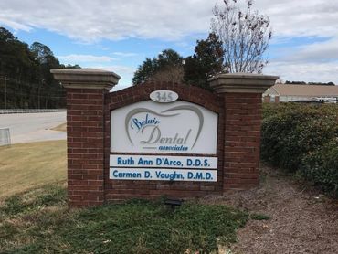 Brick sign for Belair Dental Associates with dentists' names.