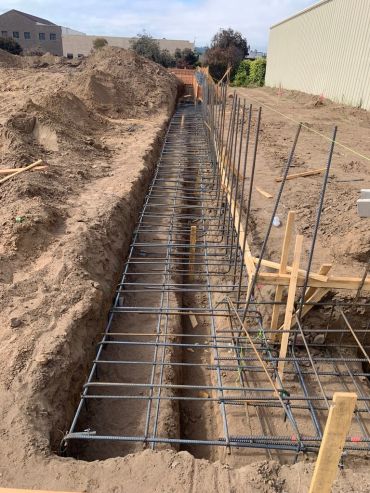 Rebar framework for foundation construction in a trench.