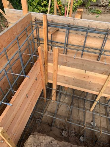 Concrete formwork with rebar grid at construction site.
