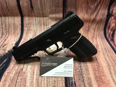 Black handgun displayed with a business card from Coyote Point Armory.