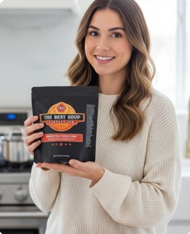 Smiling woman holding a packet of The Best Soup Company's Amishstyle Potato Soup.We are the best soup company gourmet soups for soup delivery.