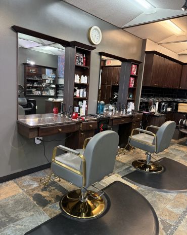 Modern hair salon with stylish chairs and a well-stocked counter.