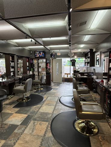 Interior of a modern hair salon with chairs and product shelves.