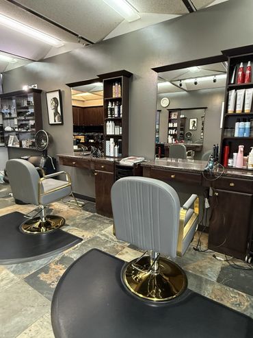 Modern hair salon with styling chairs and product shelves.