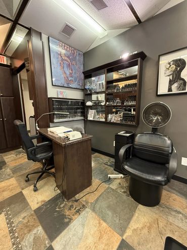 Interior of a modern nail salon with chairs, nail polish displays, and artistic wall decor.