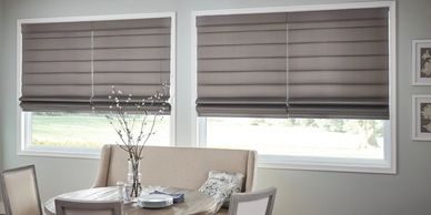 Roman blinds covering two windows in a dining room.