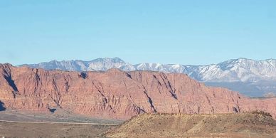Red rock mountains with snow-capped peaks in the distance.