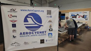 Two men working on a project at an AeroCygnet event booth.