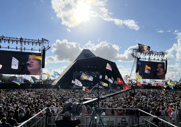 Flags are waved above the crowds in front of the Pyramid Stage, Glastonbury Festival.