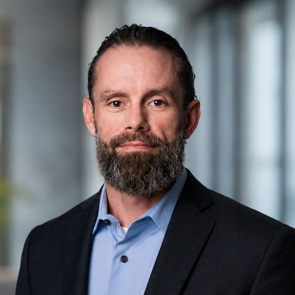 Professional man with beard wearing a suit and blue shirt.