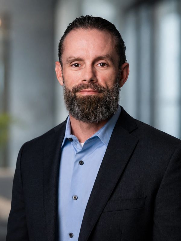 Professional man with beard wearing a suit and blue shirt.
