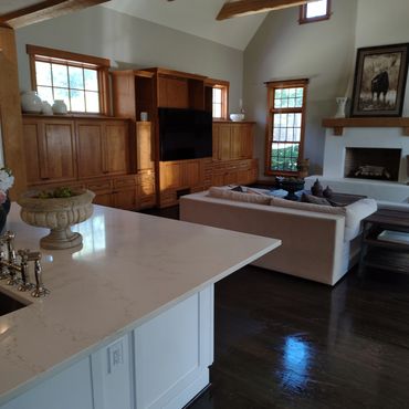 Cozy living room with wooden cabinets, a fireplace, and a beige sofa.
