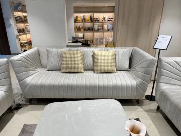 Elegant beige sofa with patterned cushions in a modern room.