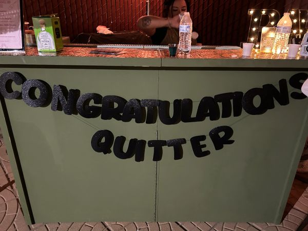 A party setup with a banner reading 'Congratulations Quitter'.