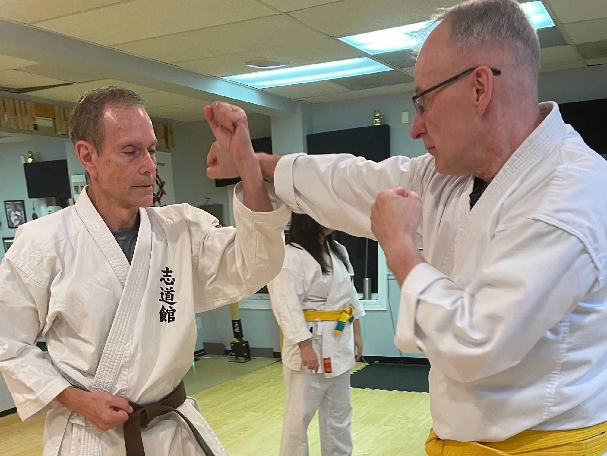 Two men practicing karate techniques in a dojo.