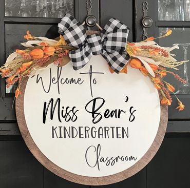 Decorative round sign welcoming to Miss Bear's Kindergarten Classroom with floral accents.