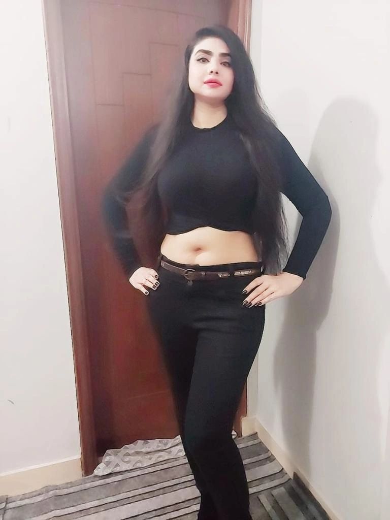 Woman in black outfit posing confidently indoors. Escorts Karachi