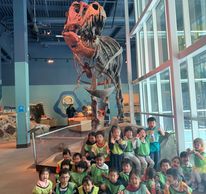 children in a museum with a t-rex