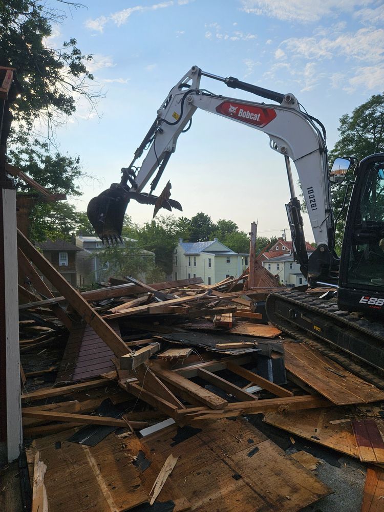 Bobcat excavator demolishing wooden structure.