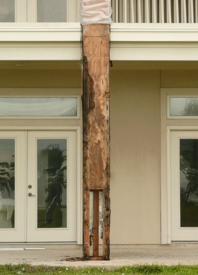Column at the rear of a tall house, the column is peeled off and the wood core is rotten.