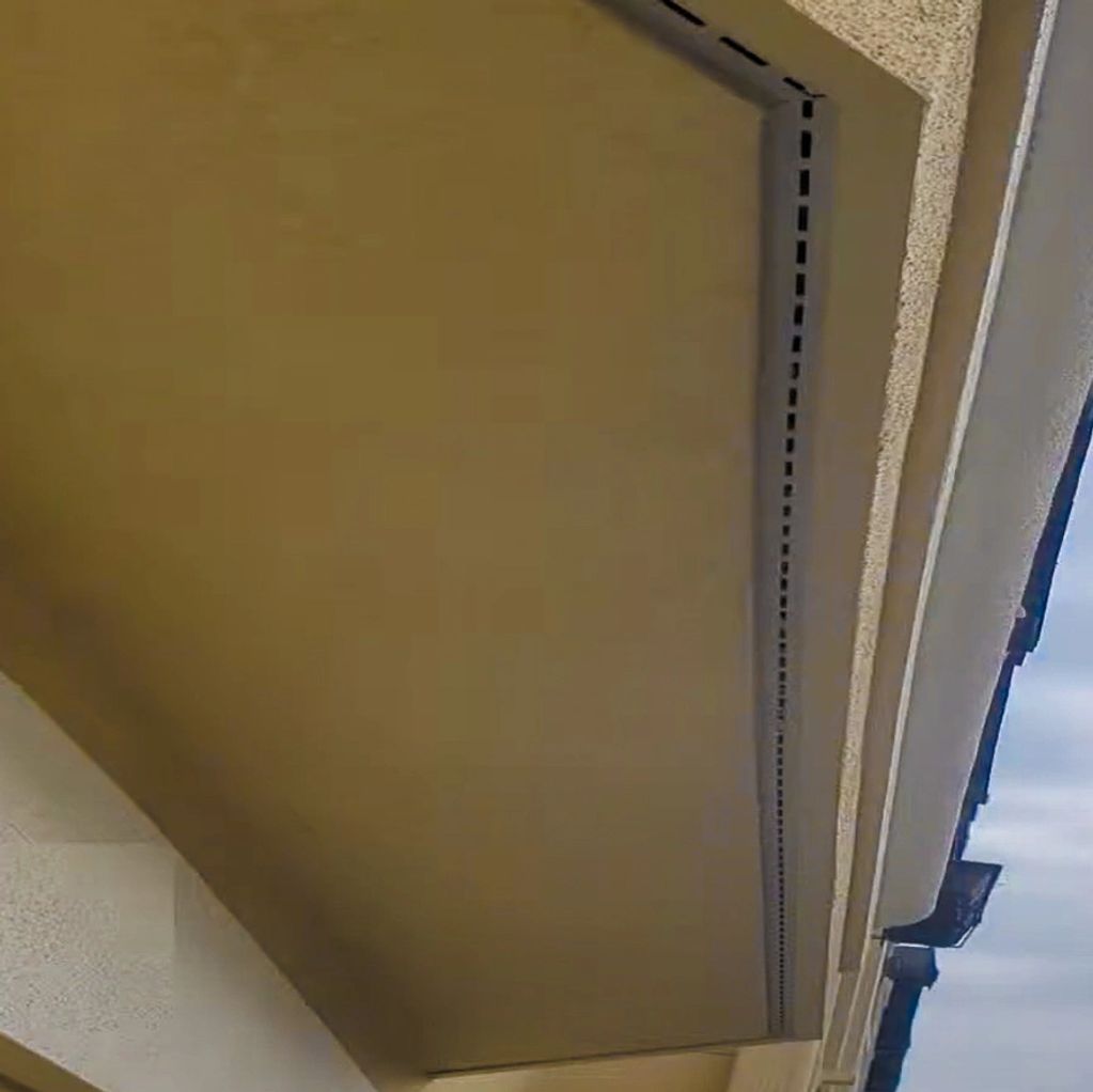 A closeup of a stucco ceiling with a built-in moisture ventilation device installed, hidden.