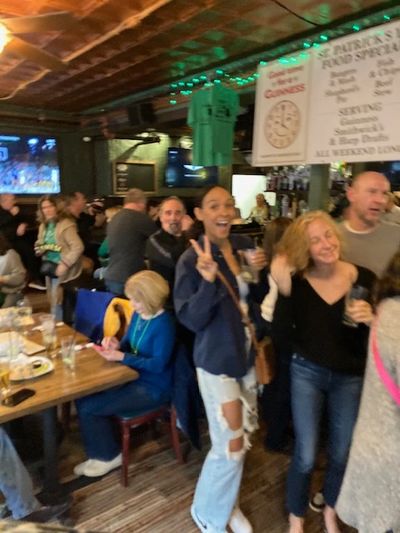 People enjoying drinks and socializing in a lively bar setting.