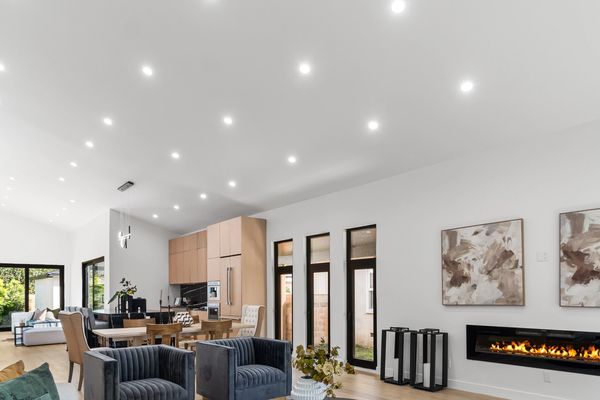 Modern open-concept living room with cozy seating and fireplace.