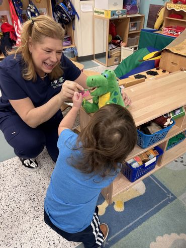 Dr. Merlino instructing children on proper dental hygiene at school visit
