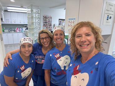 Dr. Merlino and staff smiling celebrating The 4th of July