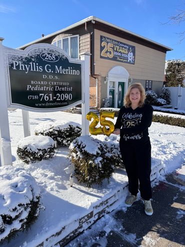 Dr. standing in front of office with celebratory 25 balloons