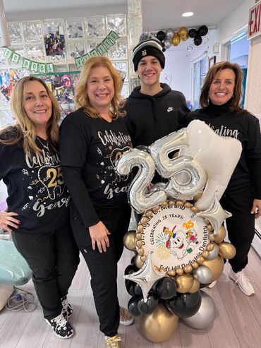 Dr. Merlino and staff smiling with patient celebrating 25th aniversary.