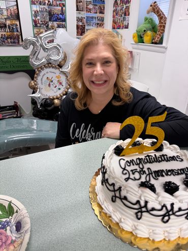 Dr. Merlino smiling with cake to celebrate 25th anniversary