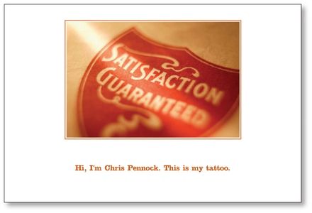 postcard with a photo of a shield tattoo with "satisfaction guaranteed"