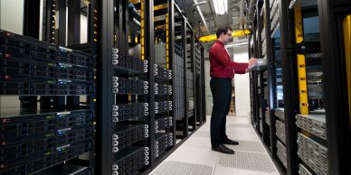 Man working inside a data center with server racks.