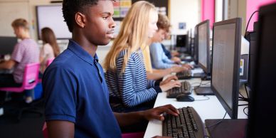 Students focused on working at computers in a classroom setting.