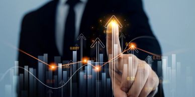 Businessman pointing at upward arrows symbolizing growth and success.