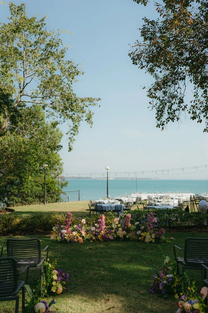 Black pencils in a gray holder next to a stack of white magazines with a camera in the background.