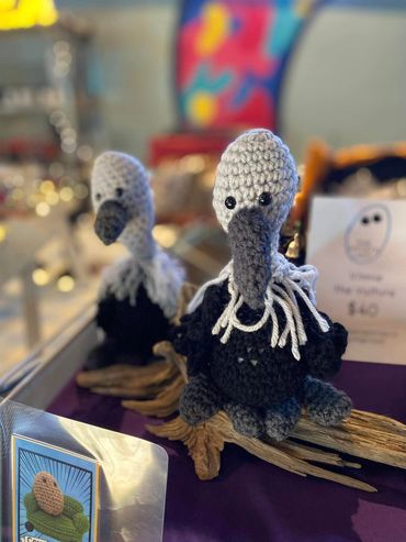 Handmade crochet birds with black and grey feathers.
