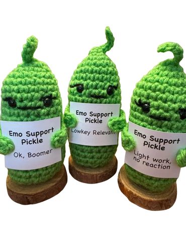 Three crocheted pickles with supportive labels.