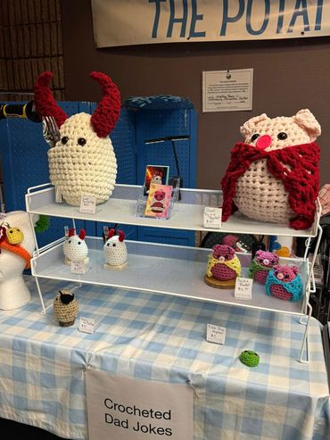 Crocheted dad joke characters display at a booth.