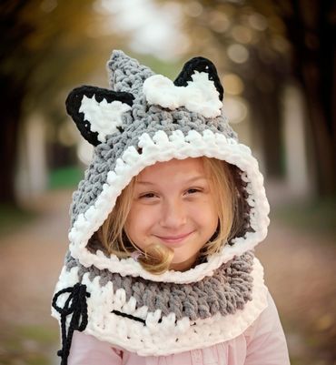 Girl wearing a cozy wolf-themed crocheted hood.