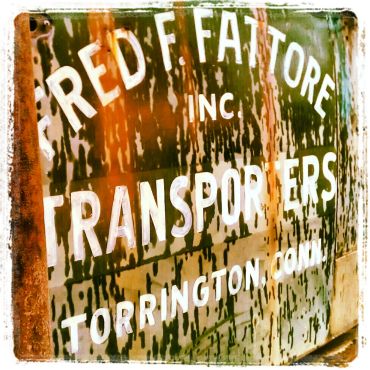 Rusty transport company sign with white text.