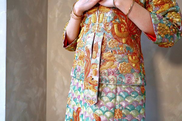Traditional embroidered outfit with vibrant colors.